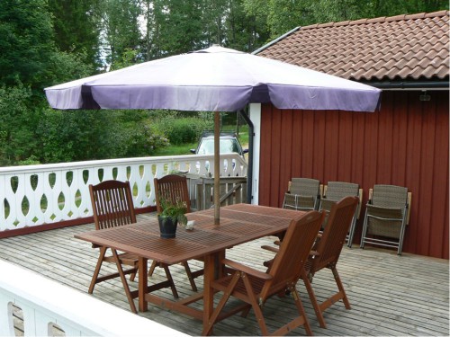 terrass med trädgårdsmöbler och parasoll